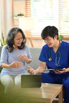 微笑医生蓝色的医疗统一的显示好健康测试结果数字平板电脑快乐高级女病人首页访问