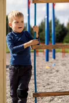 活跃的孩子蓝色的运动衫操场上绳子梯
