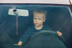 肖像孩子坐着车轮前面男孩戏剧想象开车控制广播手