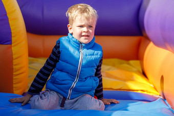 孩子色彩斑斓的操场上蹦床孩子采取打破充气反弹城堡幼儿园生日聚会，派对活动玩中心年轻的孩子