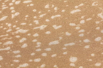 小补丁白色泡沫海滩沙子湿海洋水摘要海海洋背景