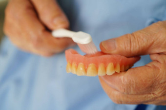 亚洲高级女人病人刷牙齿假牙牙刷咀嚼食物