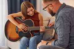 私人教训吉他老师显示玩仪器年轻的女人