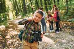 男孩双筒望远镜站前面朋友孩子们绿色森林夏天白天