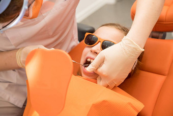 牙科板扩张下巴孩子十几岁的女孩持有矫正板手矫正医生检查牙齿牙龈女孩下巴牙科概念护圈牙齿