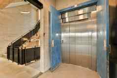 蓝色的电梯通过建筑楼梯