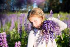 肖像可爱的快乐一年孩子女孩布鲁姆花卢平场紫色的花孩子自然概念夏天假期假期春天过敏季节童年