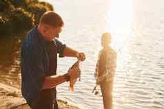 抓父亲儿子钓鱼在户外夏季