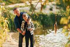 持有抓父亲儿子钓鱼在户外夏季