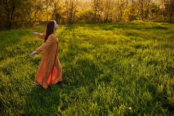 快乐的女人运行绿色场手回来享受温暖的夏天一天自然日落水平摄影自然
