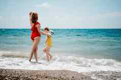 快乐爱的家庭妈妈。女儿有趣的海滩妈妈玩孩子假期假期海洋家庭生活方式爱概念