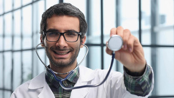心脏病专家微笑自信地显示听诊器概念医学医院医生护理