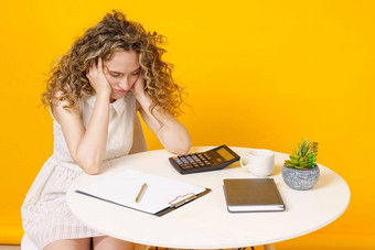 年轻的女人坐着表格累了办公室工作教育业务孤立的黄色的背景