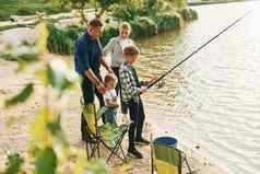 概念假期父亲妈妈。儿子女儿钓鱼在户外夏季