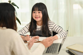 感兴趣快乐亚洲女孩首页工作导师妈妈。首页在家教育学习概念