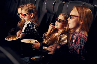 美味的爆米花集团孩子们坐着<strong>电影看电影</strong>