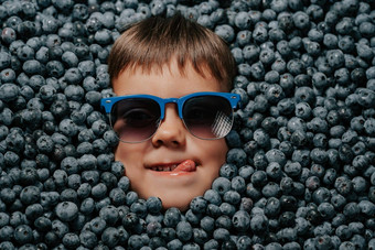 微笑男孩脸成熟的浆果蓝莓有机越桔植物
