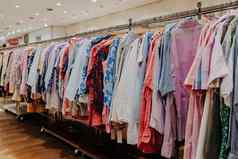 色彩斑斓的夏天衣服挂架子上衣架商店现代时尚出售