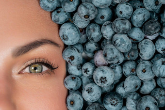 一半女人脸新鲜的成熟的浆果蓝莓有机越桔植物