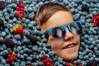 微笑男孩脸成熟的浆果<strong>蓝莓</strong>有机越桔植物