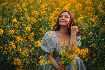 快乐女人盛开的<strong>油菜花</strong>场夫人复古的衣服春天<strong>季节</strong>