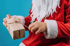 手男孩圣诞老人的服装拉字符串包装礼物盒子