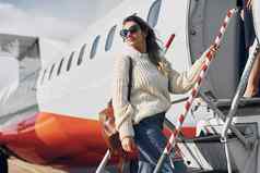 lugagge年轻的女帕桑格休闲衣服在户外飞机