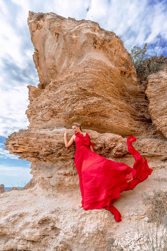 女人红色的丝绸衣服站海洋山背景衣服摇摆微风