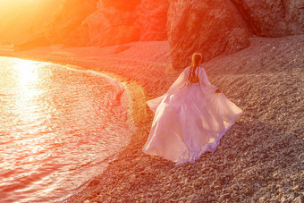 神秘的女人轮廓长头发走海滩海洋水海美丽的少女风听波抛出长白色衣服神圣的日落艺术照片回来脸