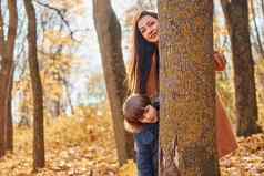 快乐的女人男孩妈妈。儿子有趣的在户外秋天森林
