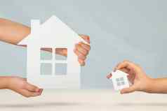 选择大小房子购买财产财产比较购买模型大小白色房子手模糊背景买房子公寓