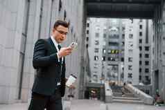 互联网沟通智能手机商人黑色的西装领带在户外城市
