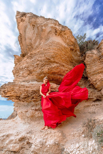 女人红色的丝绸衣服站海洋山背景衣服摇摆微风