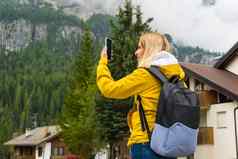 金发女郎旅游需要照片智能手机有雾的高山山