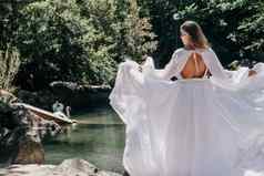 美丽的女人长白色衣服距离美丽的湖天鹅后视图