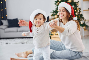 庆祝圣诞节妈妈。女儿在室内首页