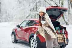 森林美丽的年轻的女人在户外红色的汽车冬天时间