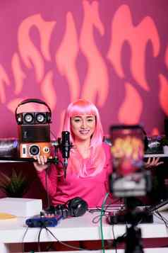 亚洲女人粉红色的头发会说话的用户专业麦克风拍摄广播
