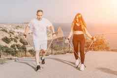 快乐中间岁的夫妇朋友练习北欧走公园海成熟的夫妇徒步旅行波兰人走练习北欧走在户外老化精神饱满地体育运动概念