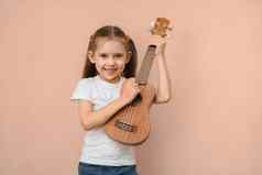 高加索人微笑快乐小学学校年龄女孩学习音乐玩吉他