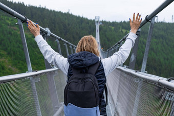 女旅游背包提高了手享受走最长的悬架桥