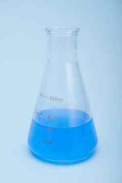 生活毕业平触底实验室瓶蓝色的化学液体解决方案孤立的蓝色的颜色背景