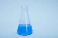 生活毕业平触底实验室瓶蓝色的流体化学解决方案孤立的蓝色的颜色背景