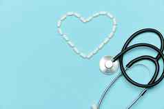 医生听诊器医疗药丸铺设形状心蓝色的背景心脏病学概念
