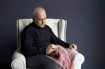 中年男人。坐在椅子粉红色的<strong>假发</strong>