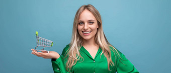 水平照片时尚的欧洲女人购物者绿色衬衫超市电车蓝色的工作室背景免费的空间