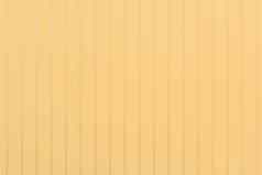 光黄色的金属栅栏温暖的奶油颜色表面纹理墙摘要背景