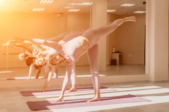 中间岁的运动女人健身教练粉红色的运动<strong>服</strong>装伸展运动普拉提<strong>瑜伽</strong>席工作室镜子女健身<strong>瑜伽</strong>健康的生活方式和谐