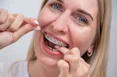高加索人女人清洁牙齿牙套牙科牙线
