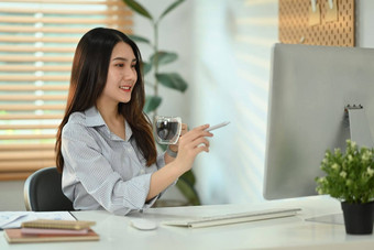 有吸引力的千禧女企业家喝咖啡分析统计数据数据在线电脑屏幕